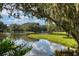Scenic view of a serene pond reflecting the sky and surrounding lush greenery at 3010 E Forest Lake Dr, Sarasota, FL 34232