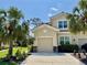 Beige two-story home with a tile roof and a two-car garage framed by lush palm trees and manicured landscaping at 3120 Oriole Dr # 101, Sarasota, FL 34243
