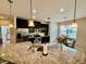 Kitchen featuring granite countertops, stainless appliances, dark cabinets, and an adjacent dining area at 3120 Oriole Dr # 101, Sarasota, FL 34243