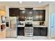 A well-equipped kitchen with stainless steel appliances, dark cabinets, and granite countertops at 3120 Oriole Dr # 101, Sarasota, FL 34243