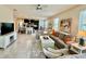 Open-concept living room with tile floors and a view of the kitchen with a large island and bar seating at 3120 Oriole Dr # 101, Sarasota, FL 34243