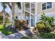 Exterior view of building with lush landscaping, white railings, and a graceful spiral staircase at 3430 77Th W St # 103, Bradenton, FL 34209