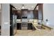 Modern kitchen featuring dark cabinets, stainless steel appliances, and granite countertops at 3430 77Th W St # 103, Bradenton, FL 34209