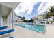 Relaxing community pool with lounge chairs, palm trees, and community buildings in the background at 3430 77Th W St # 103, Bradenton, FL 34209