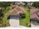 Aerial view of a well-maintained home with a spacious driveway, lush landscaping and a brown roof at 4119 101St E Ave, Parrish, FL 34219