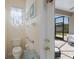 Light-filled bathroom with a toilet, towel rack, and an open view of an outdoor patio at 4119 101St E Ave, Parrish, FL 34219