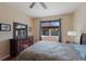 Bedroom with neutral walls, ceiling fan, wood floors, and a dresser with mirror facing a window at 4119 101St E Ave, Parrish, FL 34219