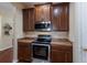 Kitchen area featuring stainless steel oven, microwave, and dark wood cabinetry at 4119 101St E Ave, Parrish, FL 34219