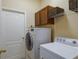 Laundry room with washer, dryer, storage cabinets, and wire shelving at 4119 101St E Ave, Parrish, FL 34219