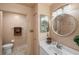 Neutral toned bathroom with toilet, vanity, circular mirror, and modern lighting at 4244 Central Sarasota Pkwy # 726, Sarasota, FL 34238