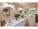 Dual-sink bathroom with framed elephant art, neutral tones, and natural light from the window at 4244 Central Sarasota Pkwy # 726, Sarasota, FL 34238
