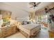 Warm bedroom featuring a ceiling fan, bedside tables, and a relaxing view of the outdoor patio at 4244 Central Sarasota Pkwy # 726, Sarasota, FL 34238