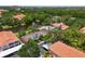 An aerial shot captures a community with a pond, tennis court, gazebo, pool, and lush landscaping at 4244 Central Sarasota Pkwy # 726, Sarasota, FL 34238