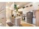 Bright kitchen with granite countertops, stainless steel appliances, and decorative open shelving with hanging plants at 4244 Central Sarasota Pkwy # 726, Sarasota, FL 34238