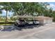 Covered parking area with assigned spaces and a nearby utility shed at 4244 Central Sarasota Pkwy # 726, Sarasota, FL 34238
