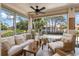Screened outdoor patio with comfortable seating, ceiling fan, and picturesque views of the community at 4244 Central Sarasota Pkwy # 726, Sarasota, FL 34238