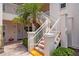 Close-up of condo building exterior featuring well-maintained white stairs and walkway leading to units on the second level at 4244 Central Sarasota Pkwy # 726, Sarasota, FL 34238