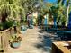 Inviting common area with patio furniture, lush landscaping, and blue umbrellas for relaxing in the shade at 435 30Th W Ave # D304, Bradenton, FL 34205
