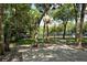 Community basketball court surrounded by trees and green space with a house in the back at 4514 Trails Dr, Sarasota, FL 34232