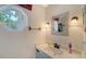 Charming powder room featuring a quartz countertop, octagonal window, updated fixtures, and a stylish mirror at 4514 Trails Dr, Sarasota, FL 34232
