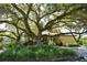 The Lakes community clubhouse framed by a large oak tree and manicured landscaping at 4514 Trails Dr, Sarasota, FL 34232