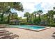 Community pool area with lounge chairs, surrounded by tropical palm trees and greenery at 4514 Trails Dr, Sarasota, FL 34232