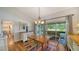 Bright dining area with wood table and seating, leading to a screened porch overlooking the lake at 4514 Trails Dr, Sarasota, FL 34232