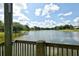 Scenic lake view from the wooden pier, showcasing calm waters surrounded by lush trees at 4514 Trails Dr, Sarasota, FL 34232