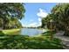 Scenic view of a calm lake with well-manicured lawn and walking trail under a blue sky at 4514 Trails Dr, Sarasota, FL 34232