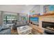Comfortable living room featuring a brick fireplace, TV, and screened-in patio with lake view at 4514 Trails Dr, Sarasota, FL 34232
