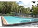 Refreshing swimming pool area with clear blue water and mature shade trees at 4514 Trails Dr, Sarasota, FL 34232