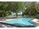 Beautiful community pool with views of a lake surrounded by lush landscape at 4514 Trails Dr, Sarasota, FL 34232