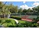 Well-maintained tennis courts surrounded by lush greenery and a garden area at 4514 Trails Dr, Sarasota, FL 34232