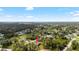 Expansive aerial view of a home nestled among lush greenery under a clear, sunny sky at 4661 Forlano Cir, North Port, FL 34291