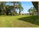 Large backyard with lush green lawn and mature trees extending to the property line at 4661 Forlano Cir, North Port, FL 34291