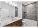 Modern bathroom featuring a marble countertop, updated fixtures, and gray tiled shower with tub at 4661 Forlano Cir, North Port, FL 34291