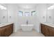 Modern bathroom with soaking tub, dual vanities, recessed lighting, and three windows at 4661 Forlano Cir, North Port, FL 34291