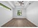 Spacious bedroom with wood floors, tray ceiling, a ceiling fan and a view of mature trees at 4661 Forlano Cir, North Port, FL 34291