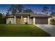 Modern home featuring a well-manicured lawn, sleek garage door and decorative black front door with horizontal panes at 4661 Forlano Cir, North Port, FL 34291