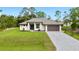 Beautiful single-story home with a well-manicured lawn, paver driveway, and modern design at 4661 Forlano Cir, North Port, FL 34291