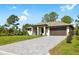 Attractive home featuring a modern paver driveway, lush green lawn, and well-maintained landscaping at 4661 Forlano Cir, North Port, FL 34291