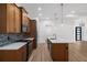 Modern kitchen with stainless steel appliances, wood cabinets, an island, and white countertops at 4661 Forlano Cir, North Port, FL 34291