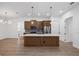 Spacious kitchen showcases an island, stainless steel appliances, and stylish pendant lighting over woodgrain laminate flooring at 4661 Forlano Cir, North Port, FL 34291