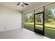 Enclosed back patio with fan, view of backyard with trees, and screen door at 4661 Forlano Cir, North Port, FL 34291