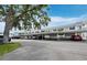 Exterior view of condo building showing carports and ample parking space and mature trees at 4745 Independence Dr # 4745, Bradenton, FL 34210