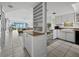 Open-concept kitchen with white cabinetry, breakfast bar, and views of living space and waterfront at 4745 Independence Dr # 4745, Bradenton, FL 34210
