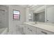 Bright bathroom featuring white tile flooring, a vanity with ample counter space and storage, and a shower-tub combination at 5004 32Nd E St, Bradenton, FL 34203