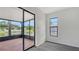 Bedroom with gray laminate flooring and sliding glass doors to the screened-in patio overlooking the tranquil pond at 5004 32Nd E St, Bradenton, FL 34203