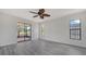 Light-filled bedroom features gray laminate flooring, a ceiling fan, and sliding glass doors to the screened-in patio with pond view at 5004 32Nd E St, Bradenton, FL 34203