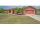 Inviting single-story home featuring an attached garage, landscaped yard, and mature palm trees at 5004 32Nd E St, Bradenton, FL 34203